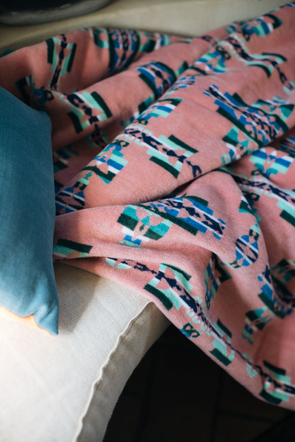 Mother and child geometric pattern with muted pink, green and blue colours on a sofa bench