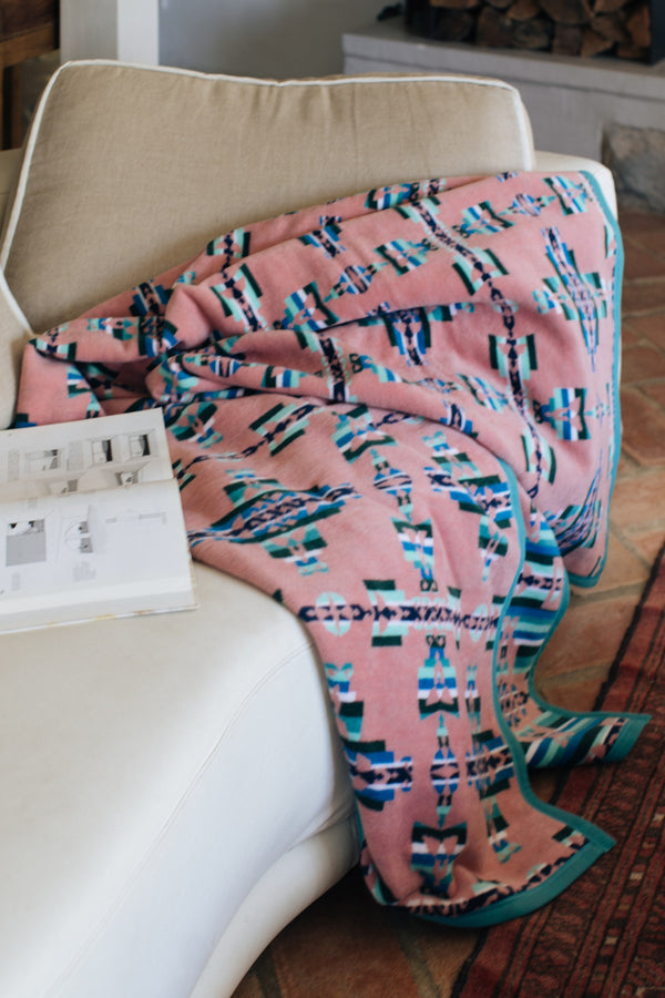 Mother and child geometric pattern blanket on a sofa with a book