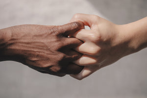 two hands interlocking fingers symbolizing cultural unity