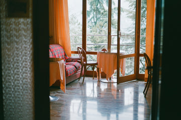 70's style terrace room with a balcony and wooden furniture with floor to ceiling windows