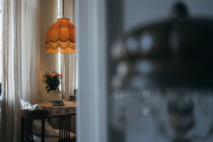 Bedroom with ceiling high windows, plush bed with 7 pillows, green leafy bed cover and a bed blanket