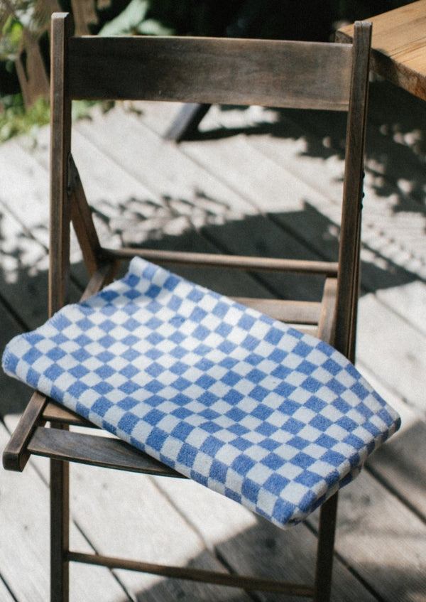 Checkered dark blue blanket folded on a chair